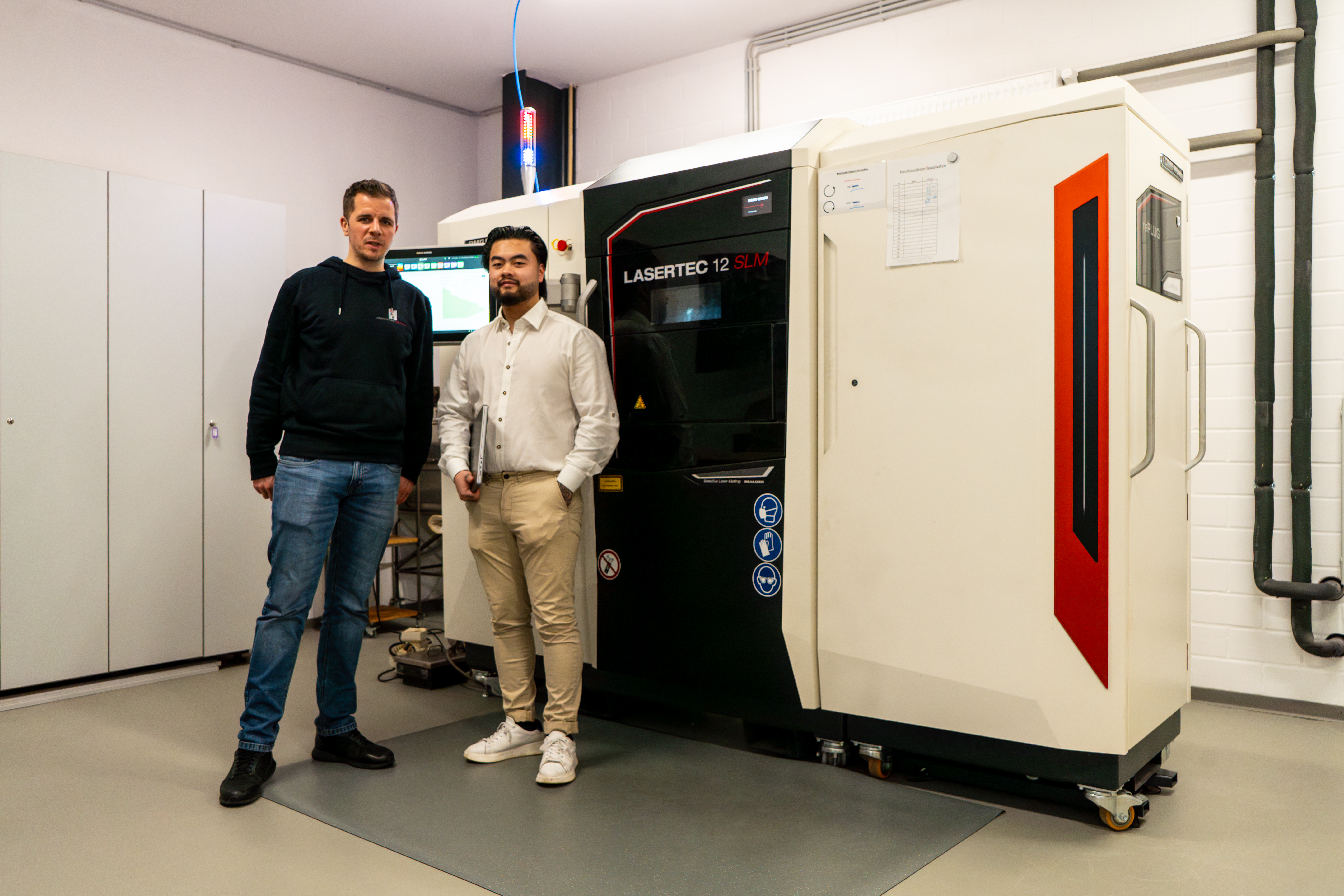 Zwei Kollegen vor einer Lasertec-Anlage